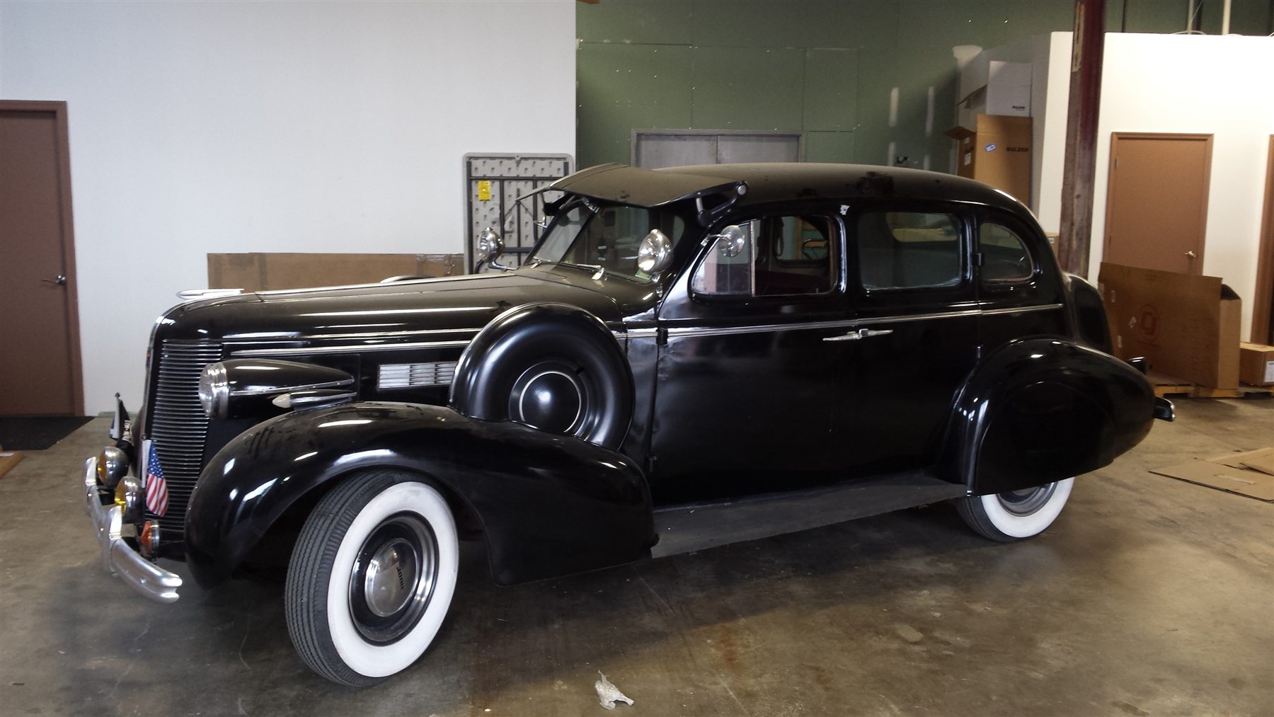 Black pre-war American sedan inside the freight warehouse