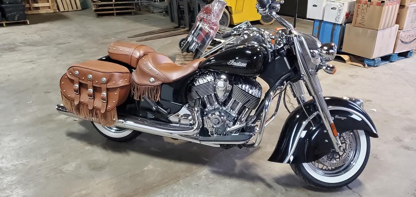 Black Indian motorcycle with leather saddlebags prepared in the freight warehouse