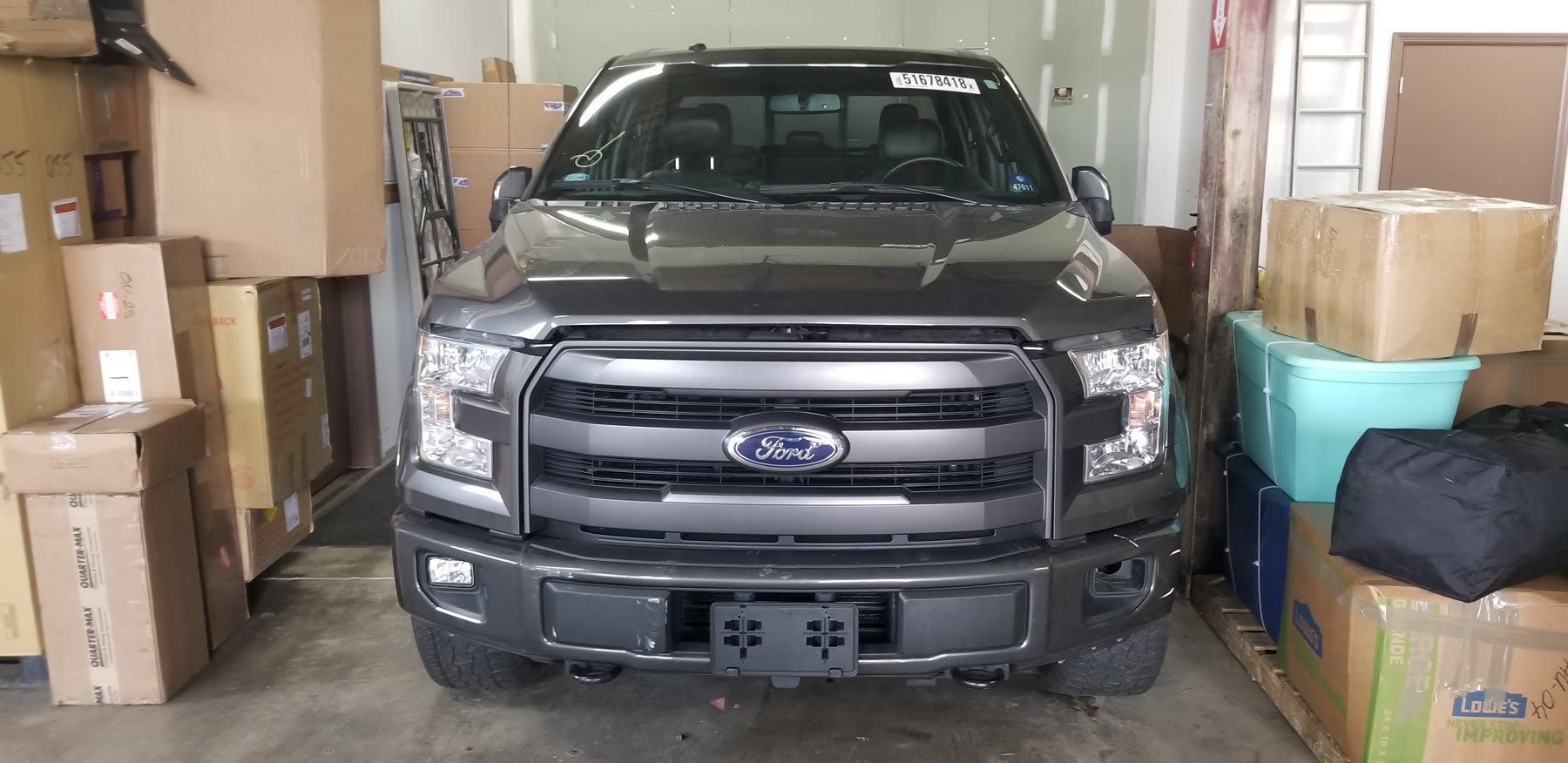 Pickup truck staged among household boxes and personal belongings in the warehouse