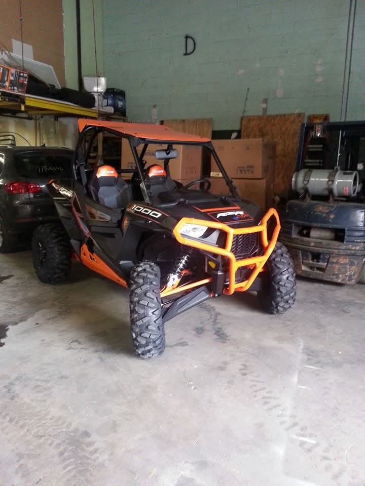 Orange and black side-by-side utility vehicle staged inside the warehouse