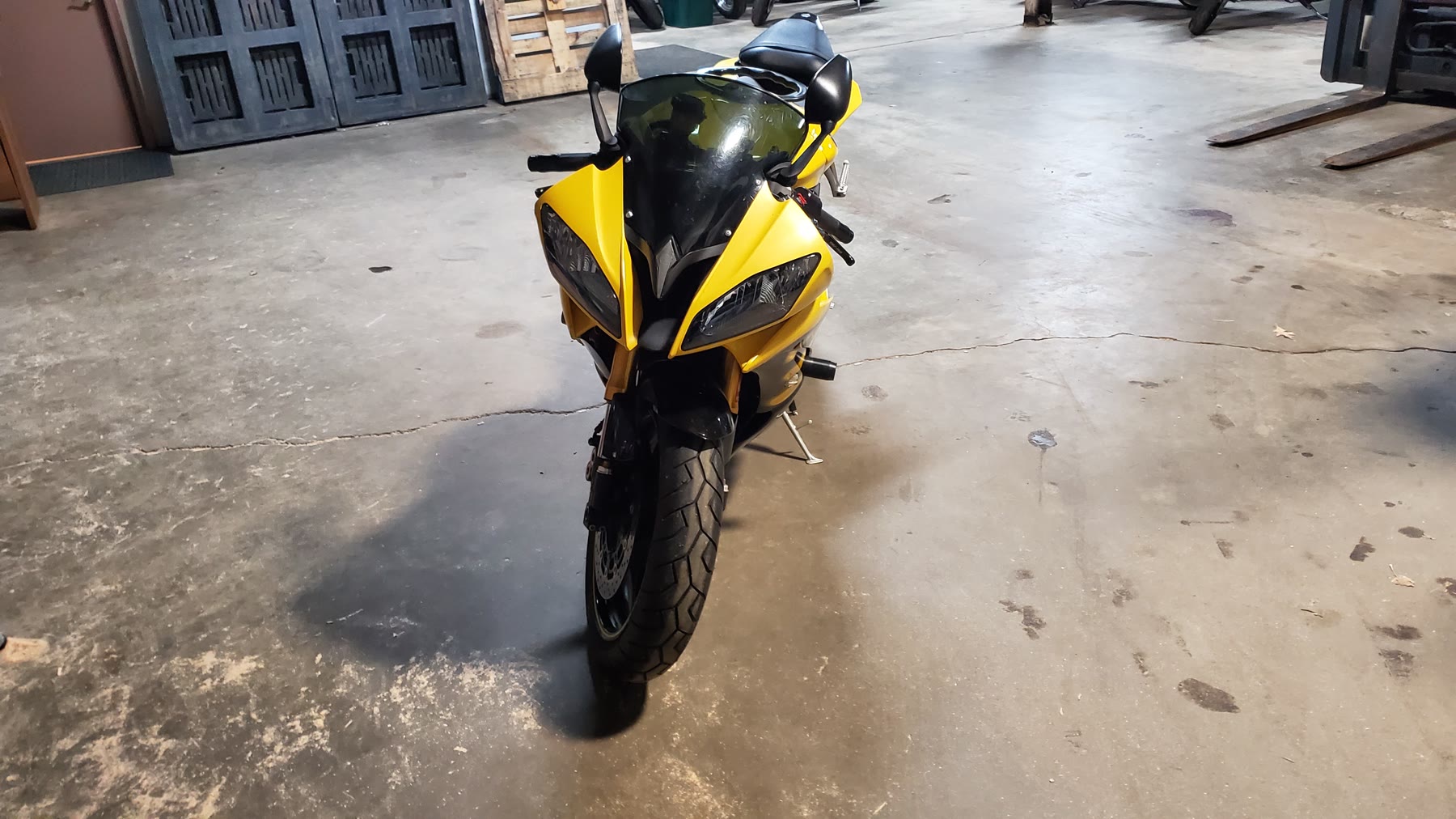 Yellow sport motorcycle staged in the warehouse before international shipping